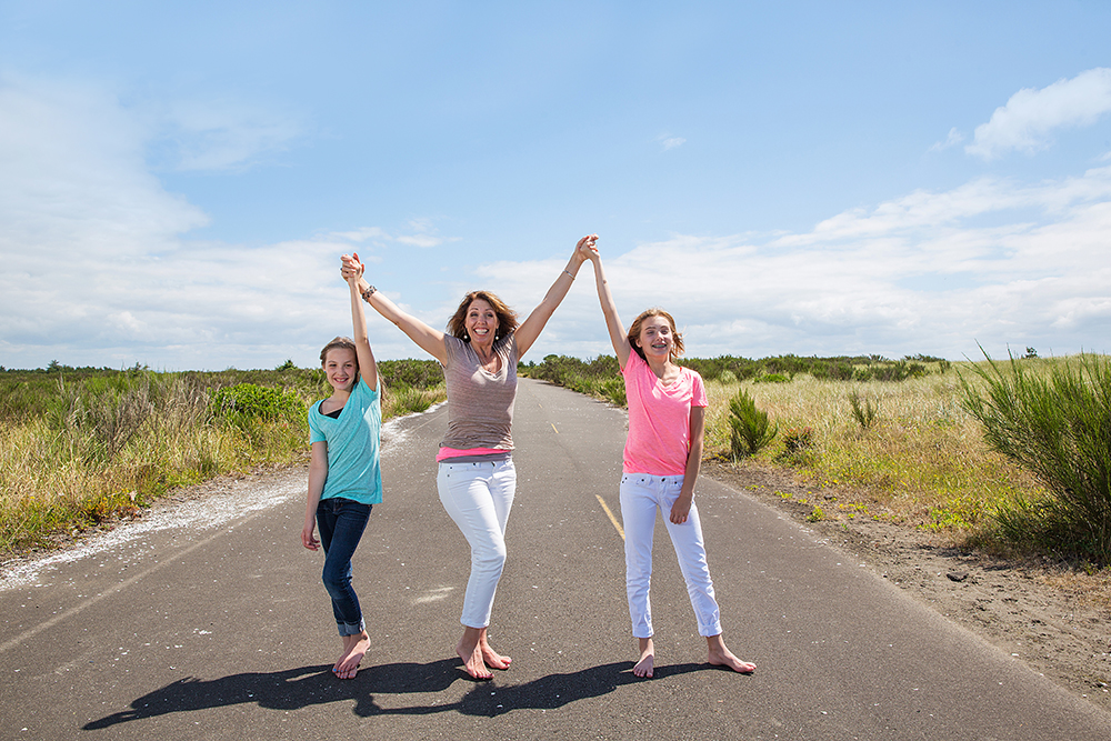 Mother and two daughters with arms raised